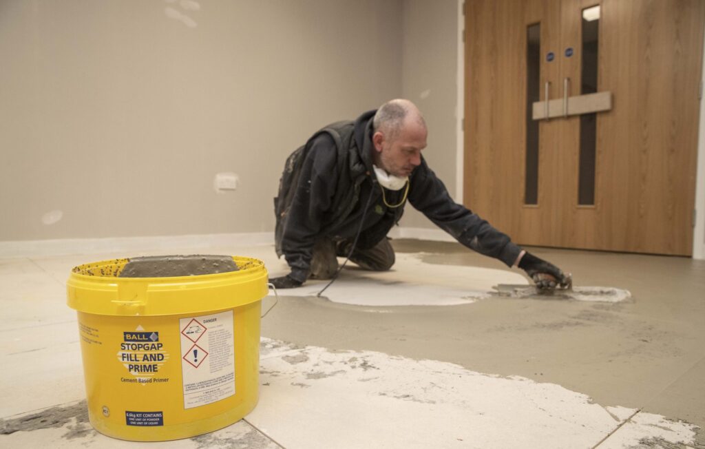 F. Ball's Stopgap Fill and Prime being applied over raised access flooring.
